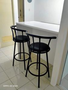 two black bar stools sitting at a kitchen counter at Cozy Boo Suite near Enchanted kingdom by Dynel in Santa Rosa