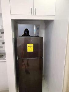 a refrigerator in a kitchen with a yellow sign on it at Cozy Boo Suite near Enchanted kingdom by Dynel in Santa Rosa