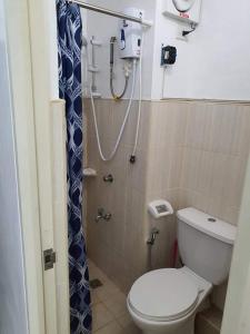 a small bathroom with a toilet and a shower at Cozy Boo Suite near Enchanted kingdom by Dynel in Santa Rosa