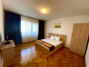 a bedroom with a bed and a wooden floor at Casa RoxAmy in Orşova