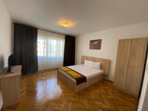 a bedroom with a bed and a television in it at Casa RoxAmy in Orşova