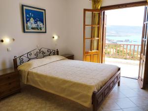 a bedroom with a bed and a view of a balcony at Olympos Studios in Amoopi