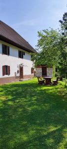 a green yard with a building and a tree at Holiday house Pr Robč in Bovec