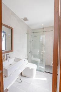 a bathroom with a sink and a toilet and a shower at Simon Hotel in Nha Trang