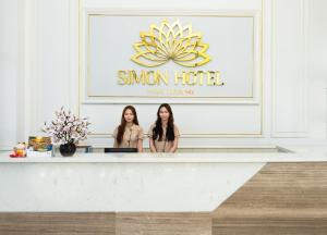 two women standing at a reception desk in a room at Simon Hotel in Nha Trang