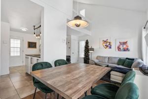 a living room with a wooden table and green chairs at INITIAL - PETIT BONHEUR - Mont-Sainte-Anne in Beaupré