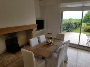 a dining room with a table and chairs and a fireplace at Deauville vue mer in Tourgeville