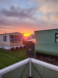 a view of a yard with two mobile homes at Stylish holiday home with fishing lakes in Fiskerton