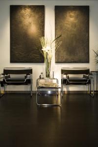 two chairs and a table with a vase of flowers on it at Aussen Alster Hotel in Hamburg