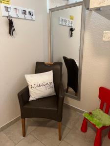 a chair with a pillow in front of a mirror at Schmidt's Plaats in Norden