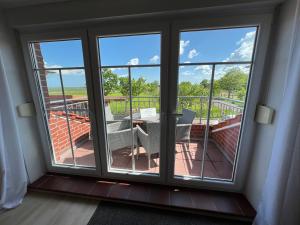 a room with a window with a view of a balcony at Schmidt's Plaats in Norden