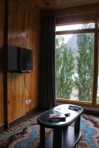 a living room with a table and a large window at Famree Resort Hunza in Hunza Valley