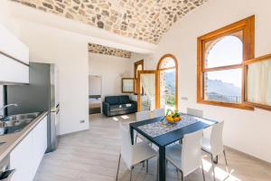 ラヴェッロにあるCasa delle Meraviglieのテーブルと椅子のあるキッチンとダイニングルーム