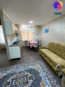 a living room with a couch and a kitchen with a table at Dimm Отель in Almaty +14 photos