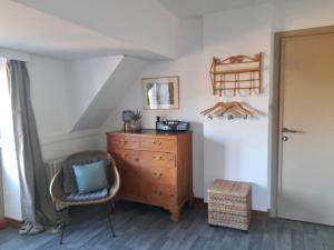 - une chambre avec une commode en bois et une chaise dans l'établissement Gîte Annastef, à Namur