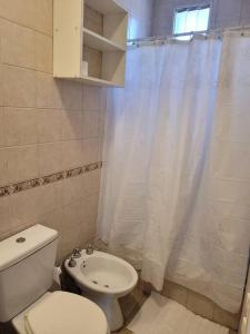 een badkamer met een toilet en een douchegordijn bij Hermoso departamento a pocas cuadras del parque in La Cieneguita