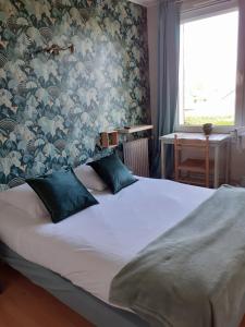 オーベルヴィルにあるMa Campagne - Le Jardinの花柄の壁紙を用いたベッドルーム1室(大型ベッド1台付)