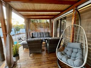- une terrasse couverte avec des chaises en osier et une balançoire dans l'établissement Mobile Home Karlo, à Biograd na Moru