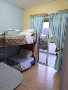 a bedroom with two bunk beds and a balcony at Alexadra's house Κάτω Αλμυρή in Kato Almiri