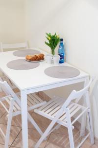 una mesa de comedor blanca con taburetes blancos en Seaside Apartment, en Gdansk