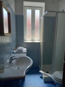 y baño con lavabo, ducha y aseo. en Albergo Locanda Sul Mare, en Isquia