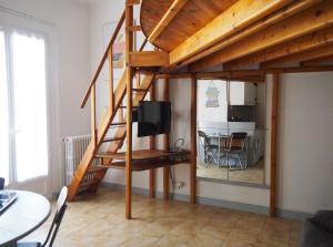 a room with a loft bed with a tv and a kitchen at Le Fontana in Nice