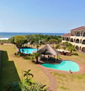 a resort with two swimming pools and a building at Cabanas del Mar in Kingsburgh