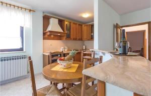 a kitchen with a table with a bowl of fruit on it at Lovely Apartment In Fazana With Kitchen in Fažana