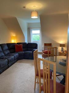 a living room with a couch and a table at Racecourse Lodge Apartment in Clifden
