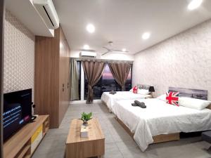 Bell Suite - The Premium Suite @ Sepang في سيبانغ: غرفة نوم بسريرين وتلفزيون بشاشة مسطحة