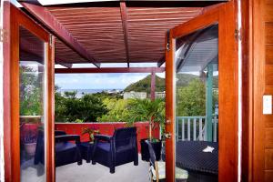 an open porch with chairs and a table on a balcony at Beachfront Cottage in Gros Islet
