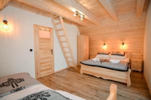 a bedroom with two beds in a wooden cabin at Tatras Residence in Poronin