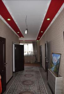 a hallway with red ceilings and a room with a painting at Kyzart Guesthouse in Bagysh