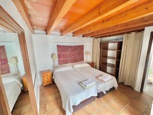 タリファにあるApartamentos Tarifa Castilloの木製の天井が特徴のベッドルーム1室(ベッド1台付)