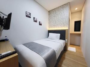 a bedroom with a bed and a television in it at Grand Plaza Boutique Hotel in Karawang