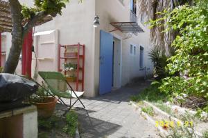 エーグ・モルトにあるrez de chaussée studio climatisé dans villaの青い扉と緑の椅子のある路地