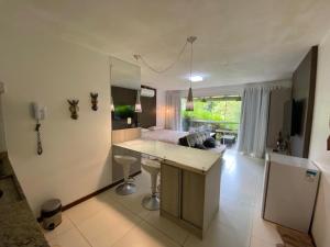 a kitchen with a desk and a room with a bed at Villas do Pratagy Temporada Limão in Maceió