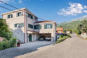 a house with two cars parked in front of it at Villa Forest in Kotor