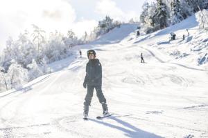 une personne faisant du snowboard sur une piste enneigée dans l'établissement Straand Hotel, à Vradal