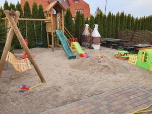 a playground with toys in the sand in a backyard at WCZASOWISKO TOLKOWO in Jarosławiec