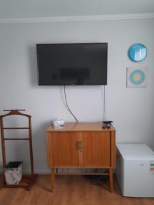 a living room with a tv on a wall at Casadenise in Santiago