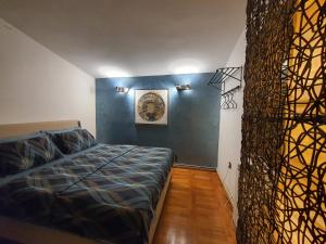 a bedroom with a bed and a blue wall at La Grande Apartments in Kotor