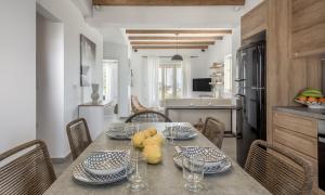 a kitchen and dining room with a table and chairs at Milos Zen Suites in Adamantas