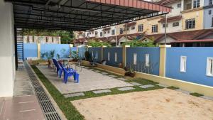 a patio with blue chairs and a blue wall at Johor Bahru 6 Bedrooms Corner House: Big & Comfort in Johor Bahru
