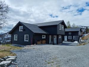 a black house with a driveway in front of it at Fosskamben Panorama Sogndal in Sogndal