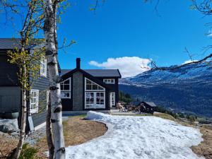 a house in the mountains with snow on the ground at Fosskamben Panorama Sogndal in Sogndal +24 photos