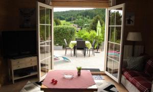 a living room with a door open to a patio at Appartement spacieux à Xonrupt-Longemer + Sauna in Xonrupt-Longemer