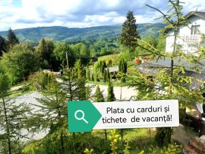 een uitzicht op een tuin met een bord met de tekst plaza cu carril bij Alpina Panoramic in Moisei