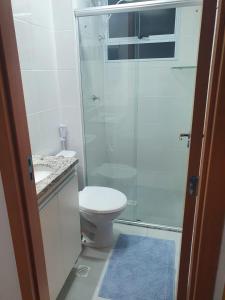 a bathroom with a toilet and a glass shower at Ap NOVO 5 min do Shopping Pantanal in Cuiabá