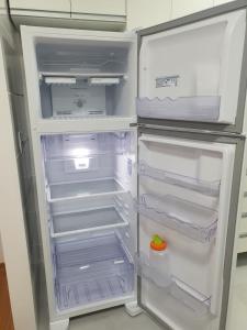 an open refrigerator with its door open at Ap NOVO 5 min do Shopping Pantanal in Cuiabá
